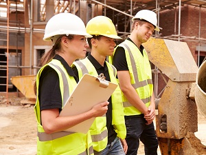 New construction workers listening to a safety presentation at a construction site.
