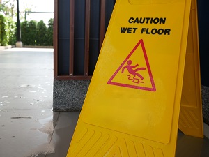 A yellow caution wet floor sign in an industrial workplace.