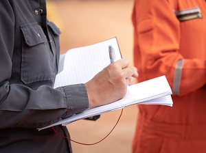 Worker with a notepad conducting an incident investigation.
