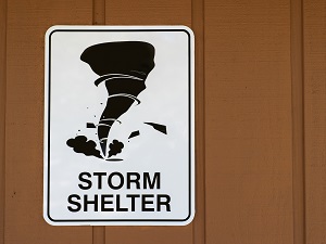 Storm shelter sign on a brown building.