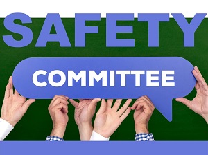 Hands holding up a sign that says Safety Committee.
