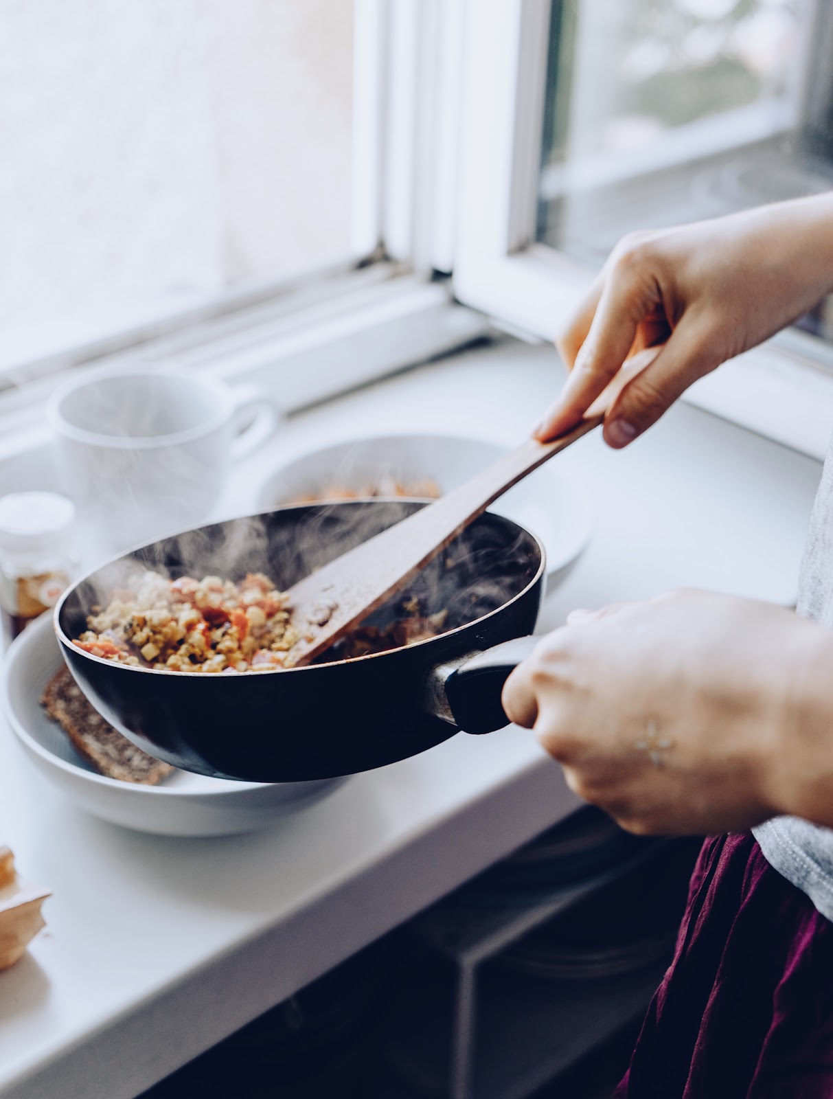 Stirring food inside a hot dish while cooking the favorite meal of a loved one