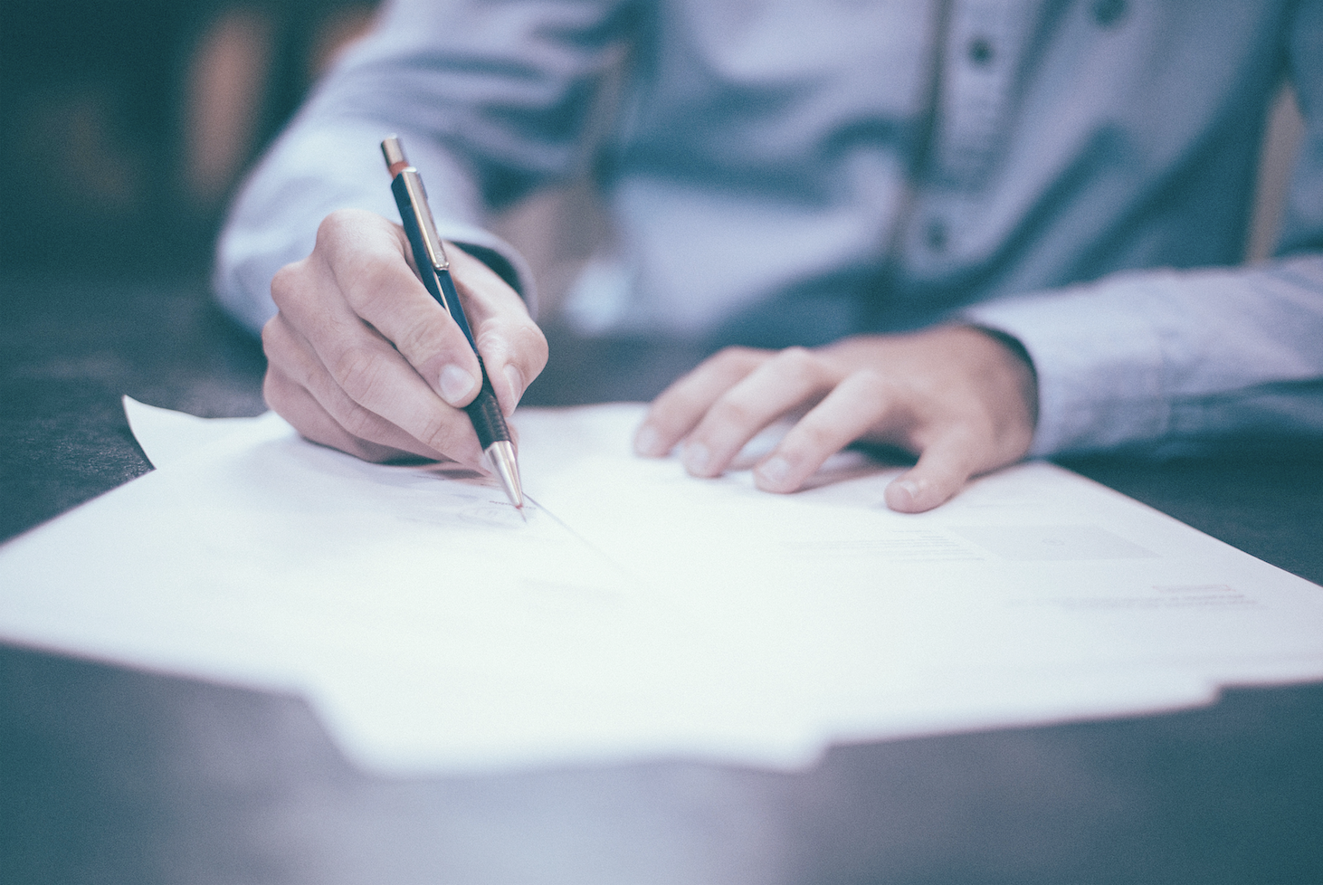 Pen in hand while writing a remembrance letter to a loved one following their loss