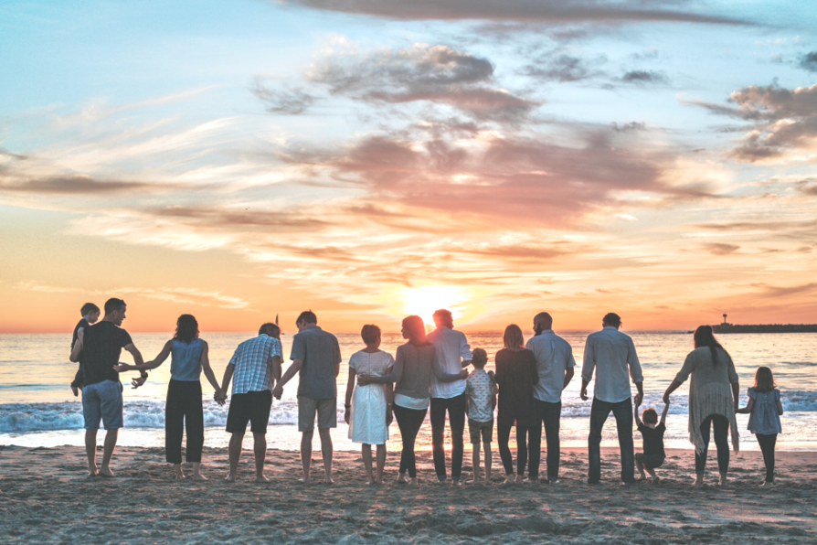 Happy family gathers near ocean in memory of loved one