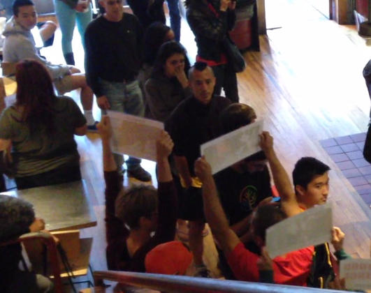 Customers, including Jude, turn and stare, as activists reveal themselves with the message: Someone, Not Something.