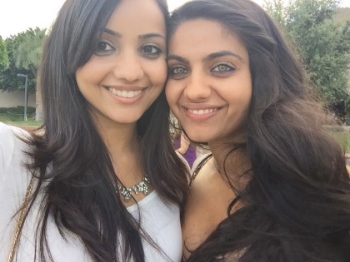 Priya (on the right) and her sister embracing and smiling.