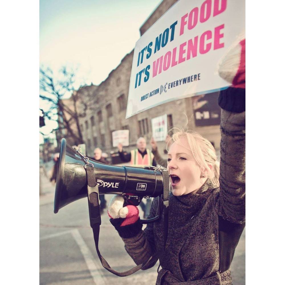 DxE Toronto activist Jenny Henry speaks into a megaphone powerfully for animals.