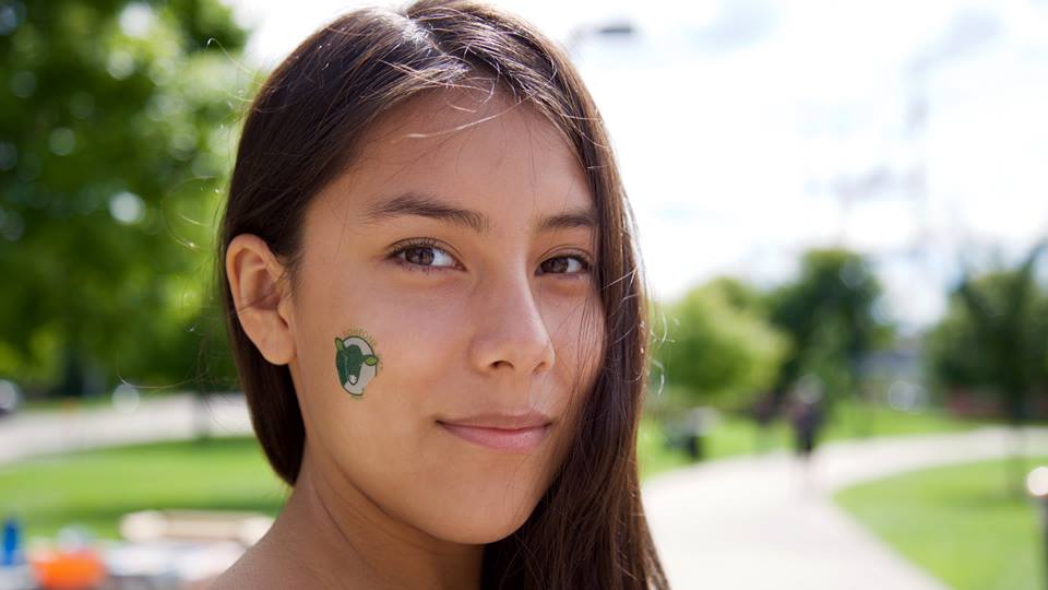 Ana's face adorned with an animal rights tattoo