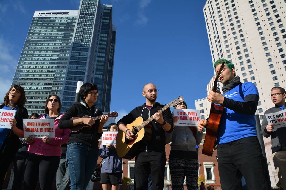 Samer, in the middle, plays guitar at a musical demonstration