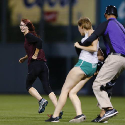 Alyssa (on left) and Kaelyn running onto the baseball field.