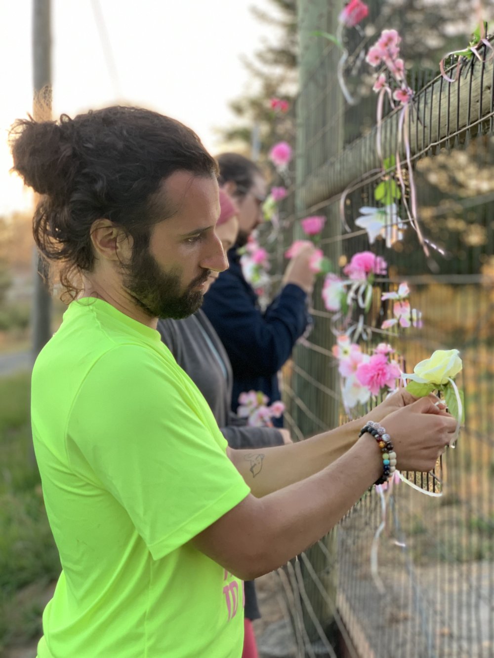 An activist arrested at the farm last month ties a flower to the gate outside Reichardt Duck Farm in Petaluma