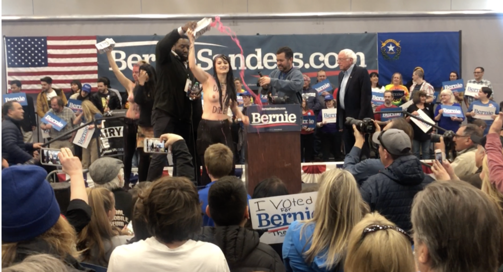 Rachel Ziegler (center) disrupting Bernie Sanders’ speech (Credit: Direct Action Everywhere)