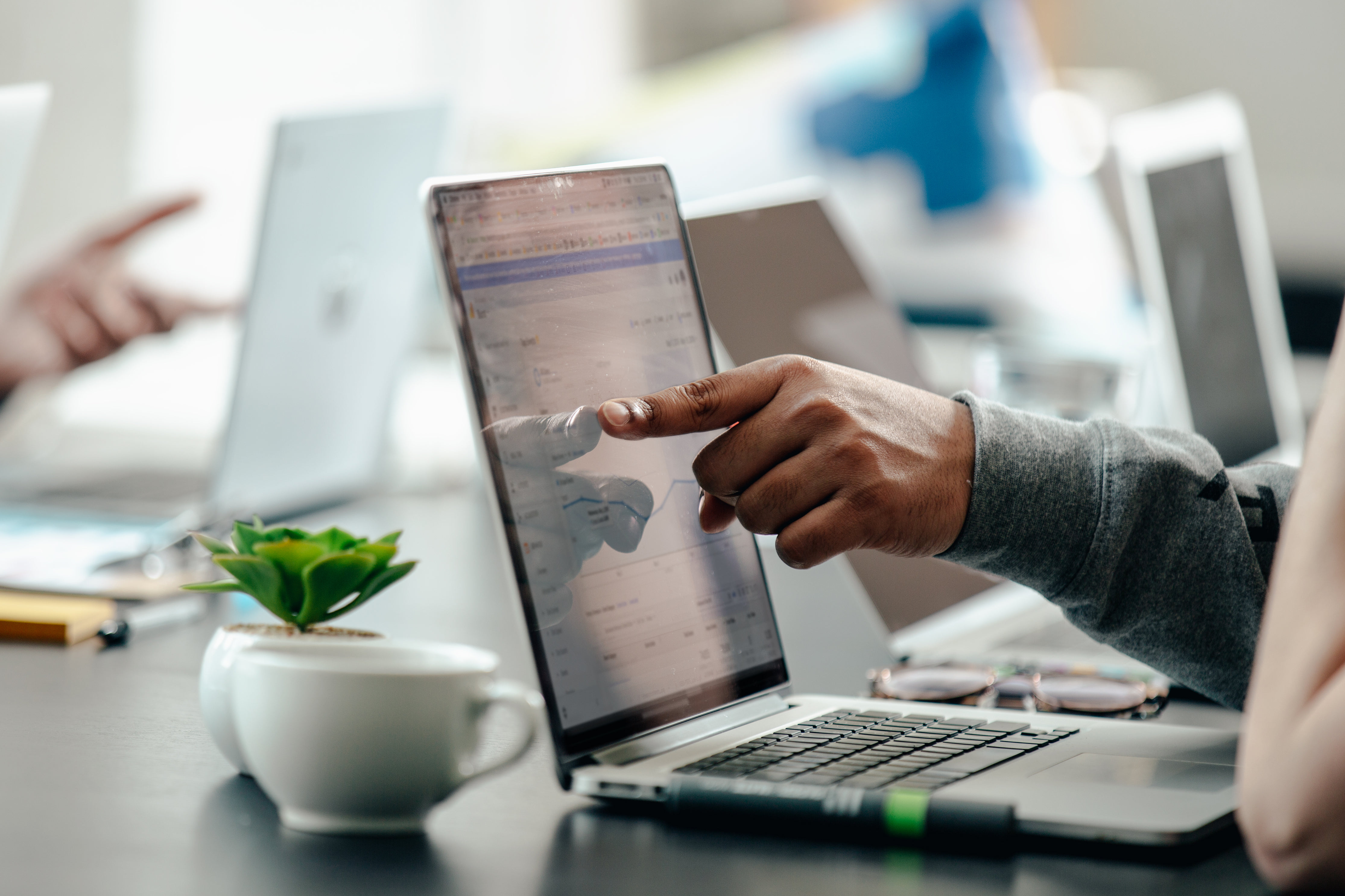 An entrepreneur pointing at data on his laptop to pinpoint what his company needs