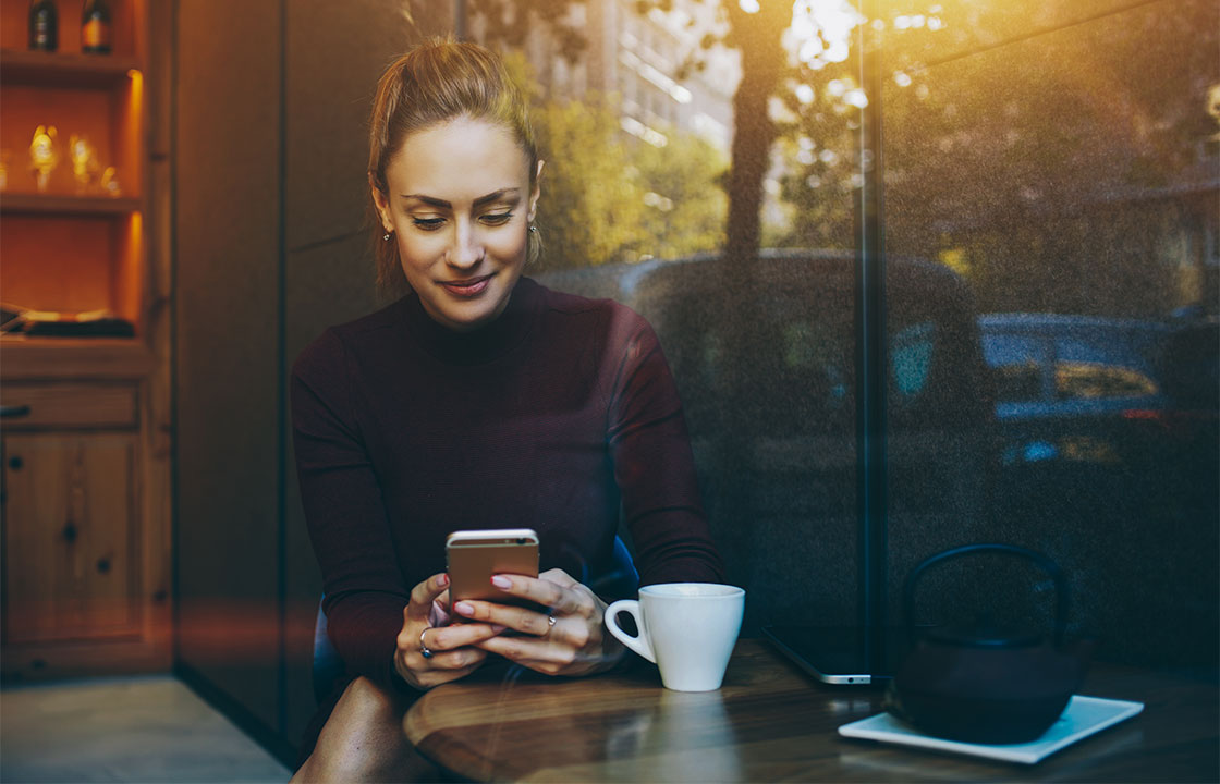 A young lady using a smart phone in a cafe