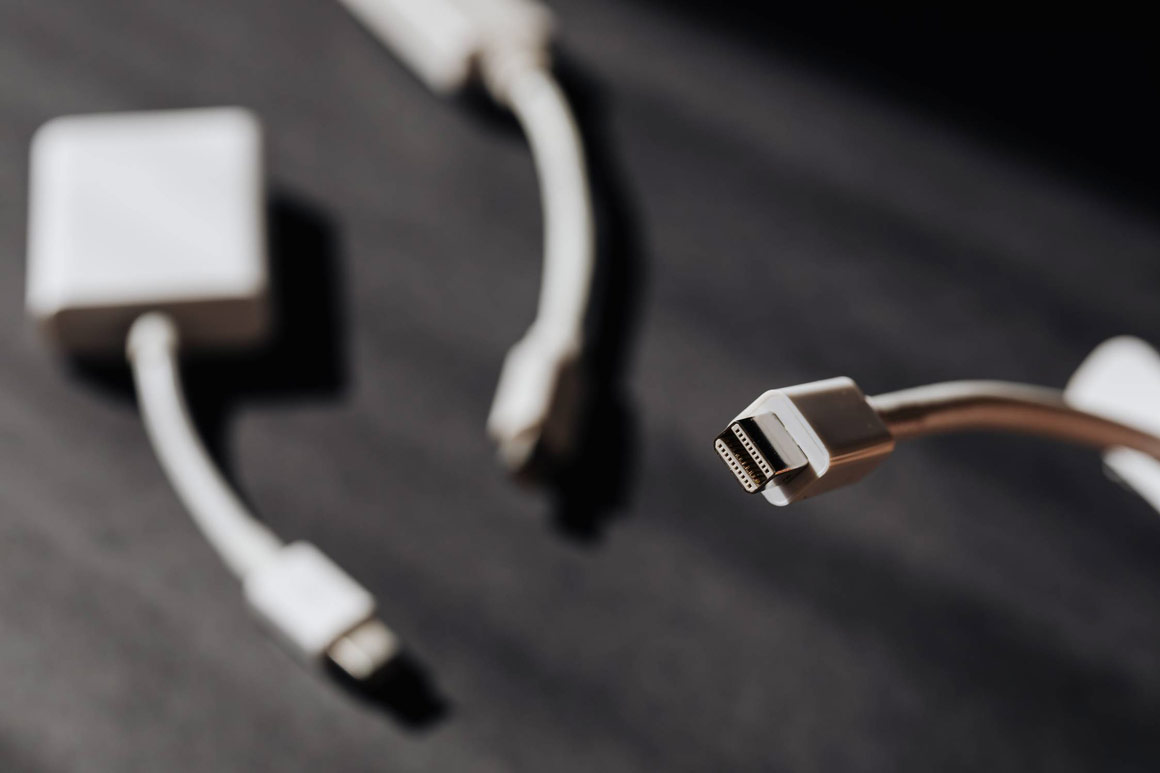 Three computer cables on a dark desk.