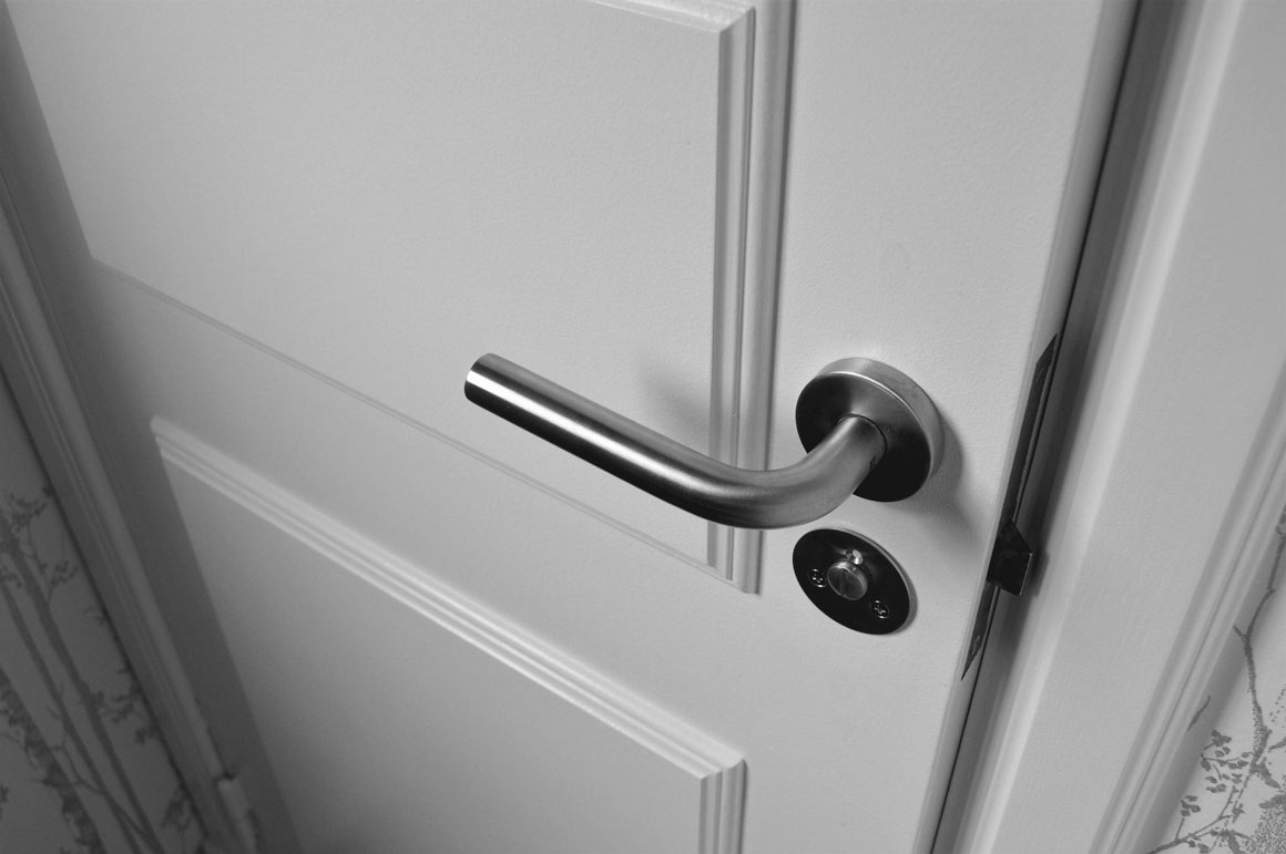A white closed door with a modern door handle.
