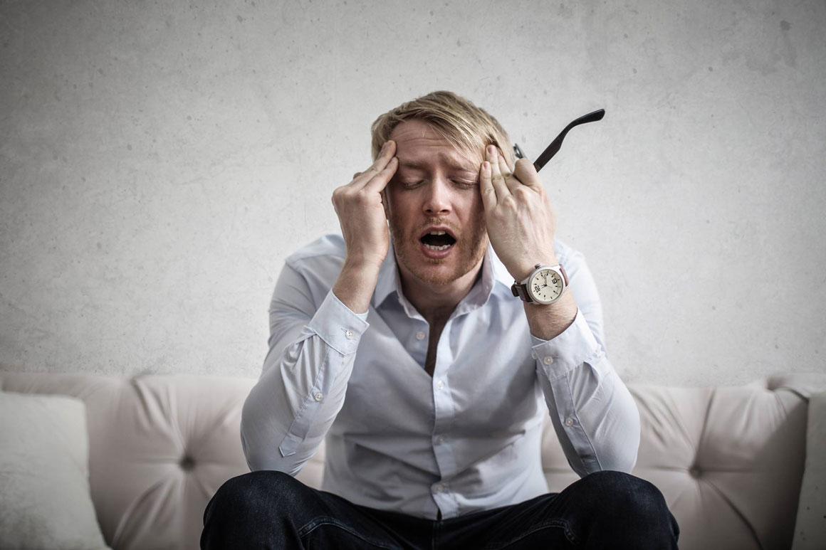 A man holding his head in frustration.