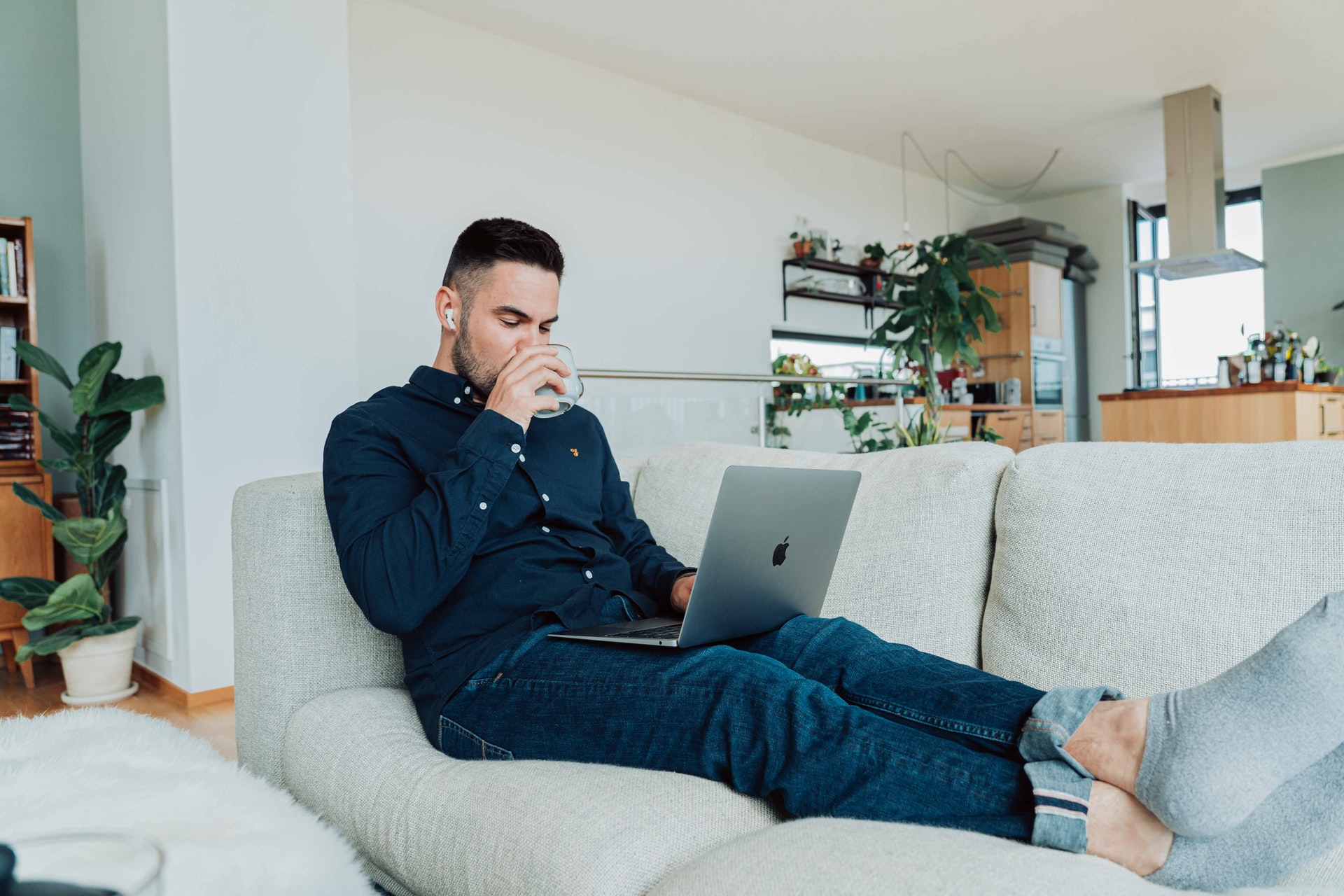 Employee comfortably working from couch on laptop