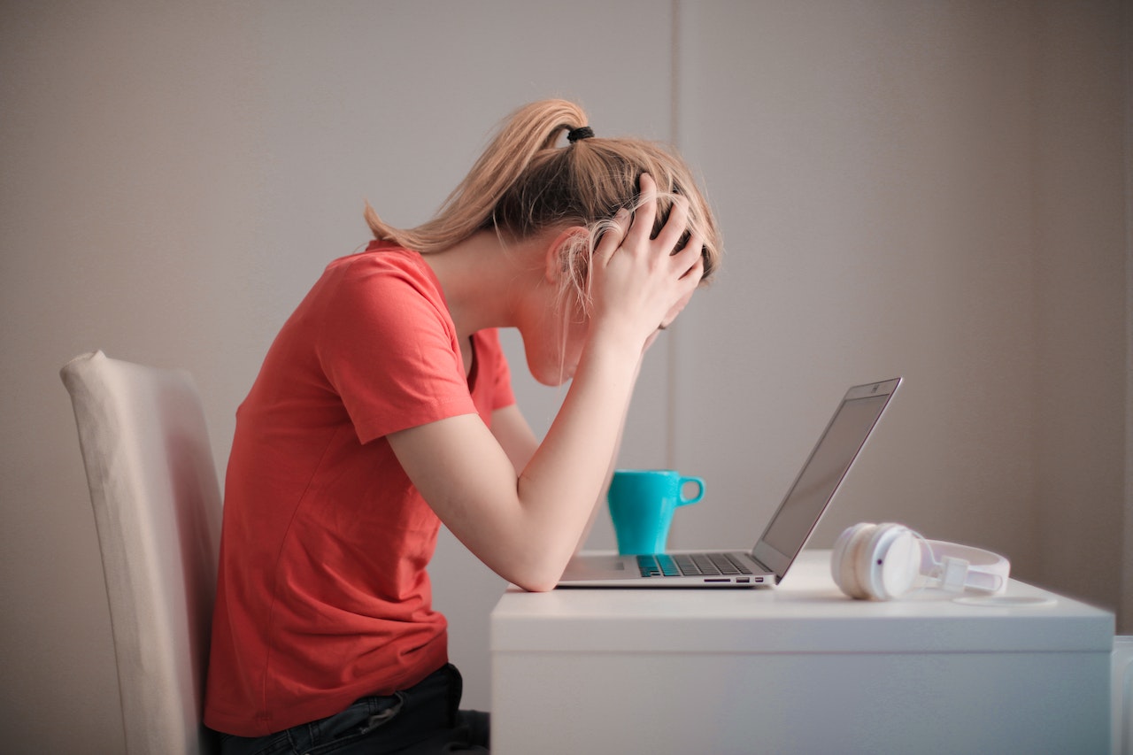 Overwhelmed woman at laptop