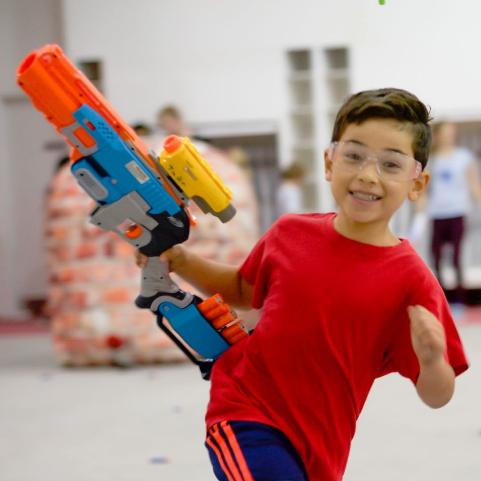 A child playing with a nerf blaster