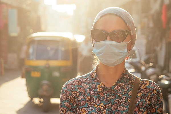 Woman in Asian street scenery, wearing face mask