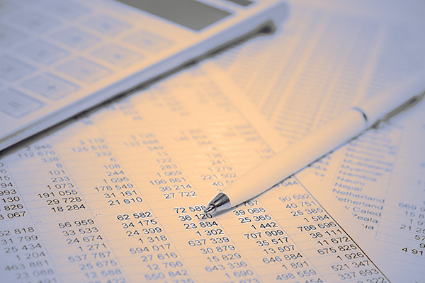 photo of tables with many numbers, a pen and a calculator