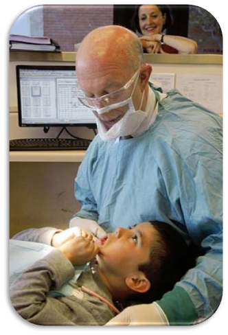 Dentist wearing FaceView Mask examining a child