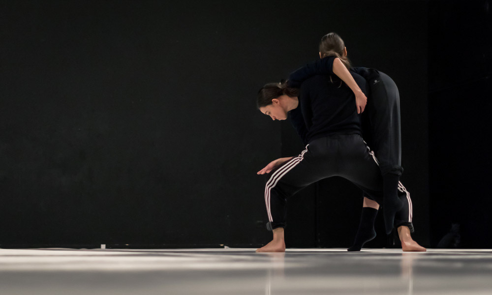 Anna Kempin and other dancer are making complex modern dance moves during a rehearsal