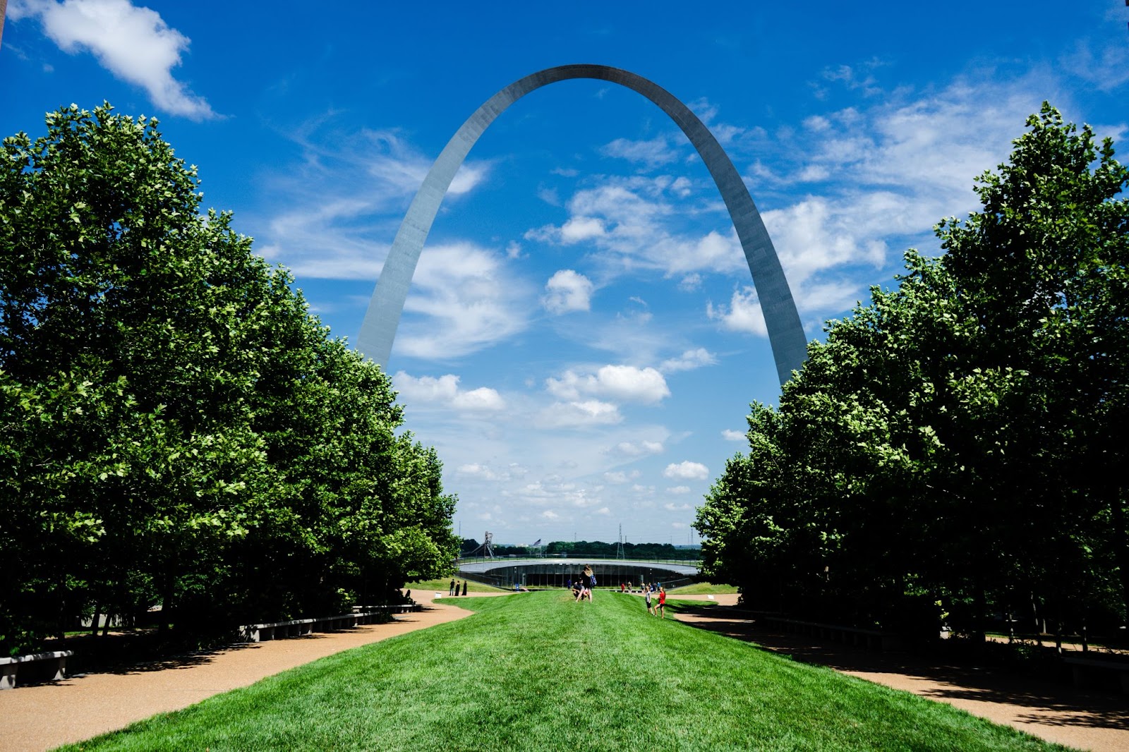 Grassy park area in front of the Gateway Arch with a pretty blue sky