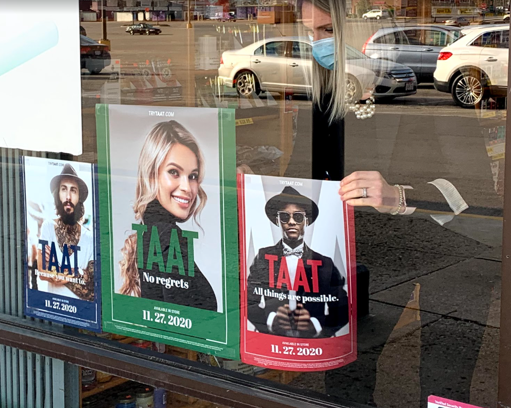 Promotional in-store graphics being placed in the window of one of Taat’s retail points of sale in Ohio.