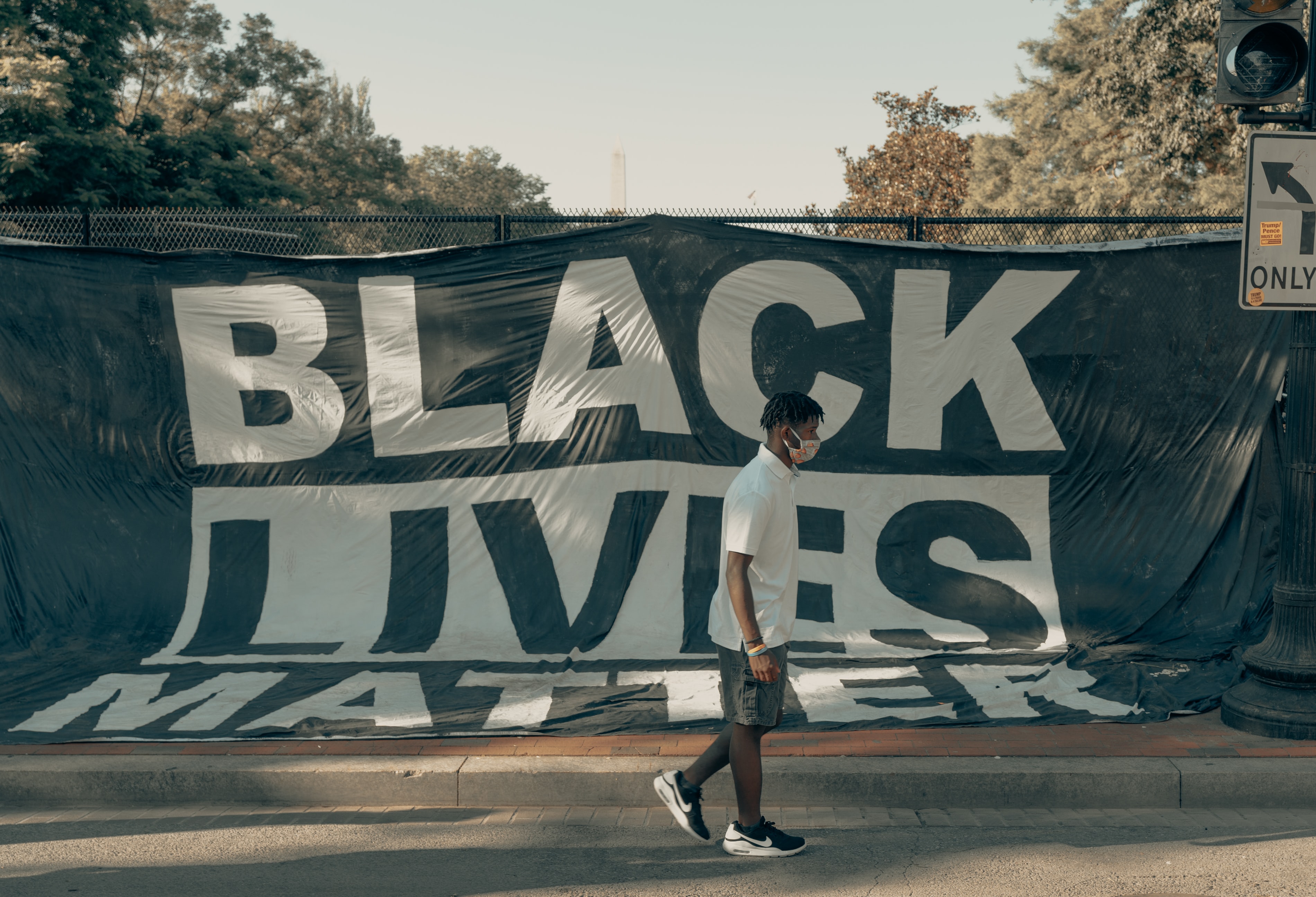 Black Lives Matter protest with guy walking in front with mask