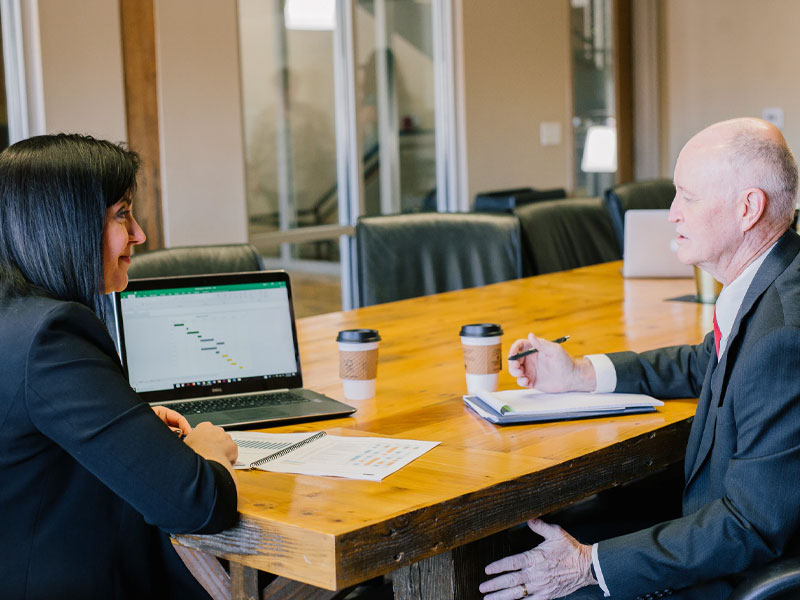 An young woman and an older man having a meeting.