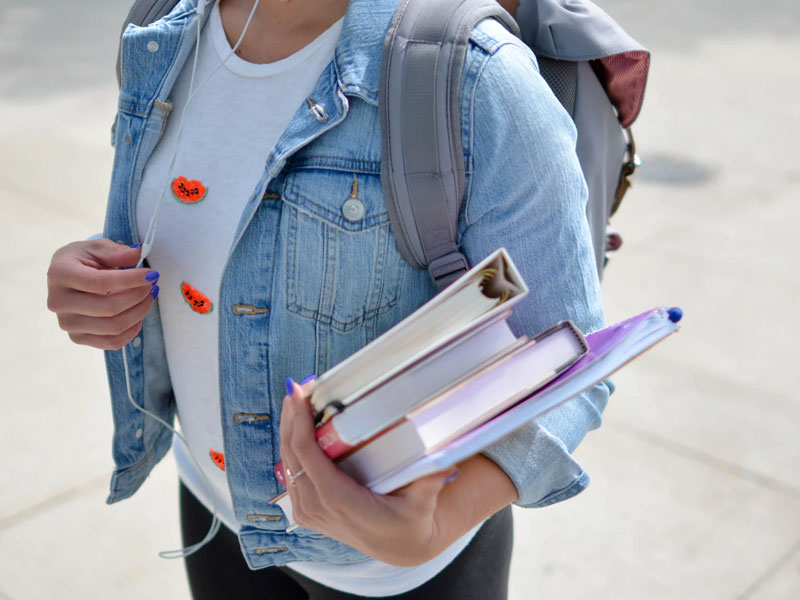 A girl carrying books.