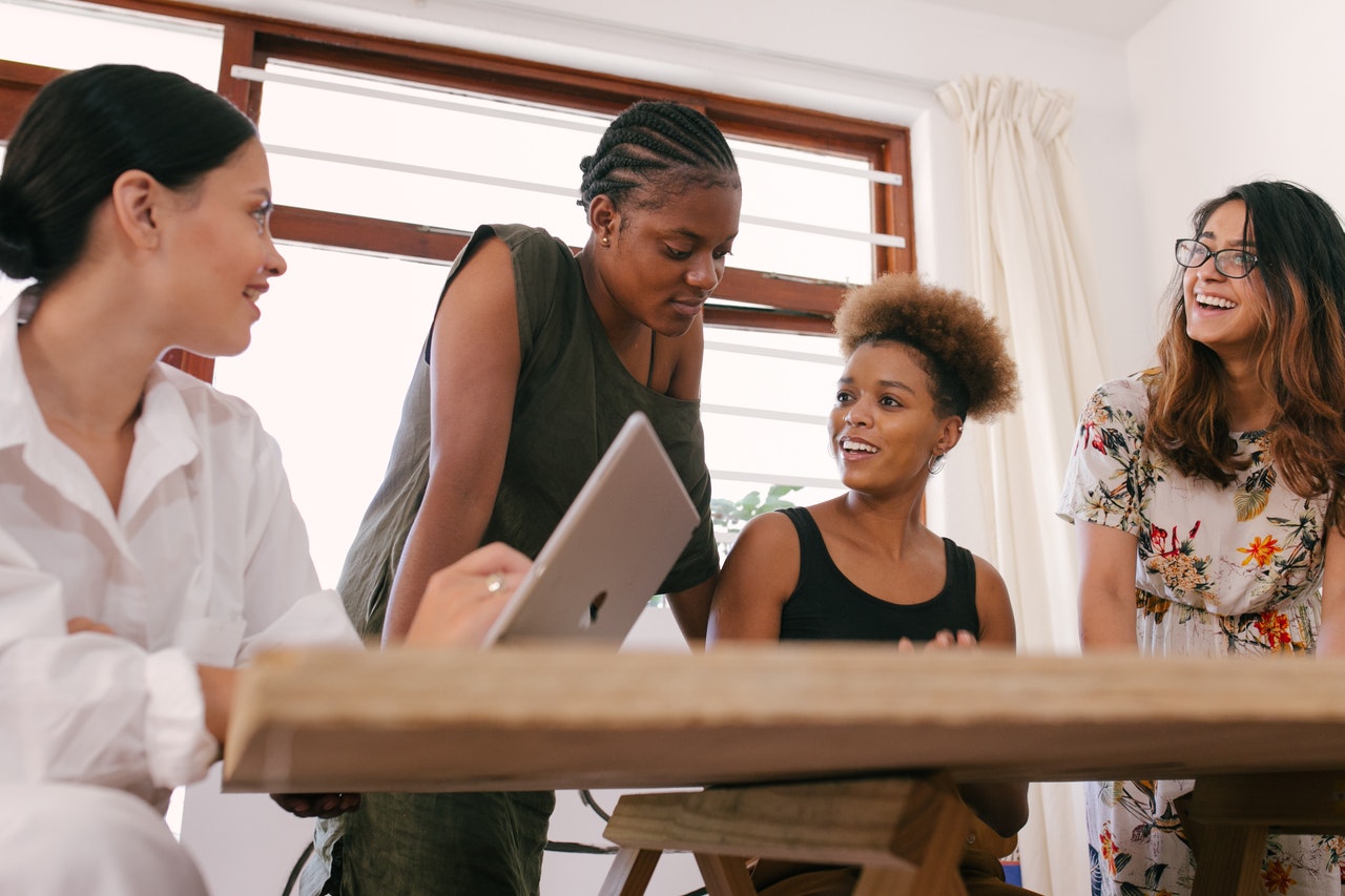 Team of dark, medium, and light-skinned women talk about hiring for diversity.