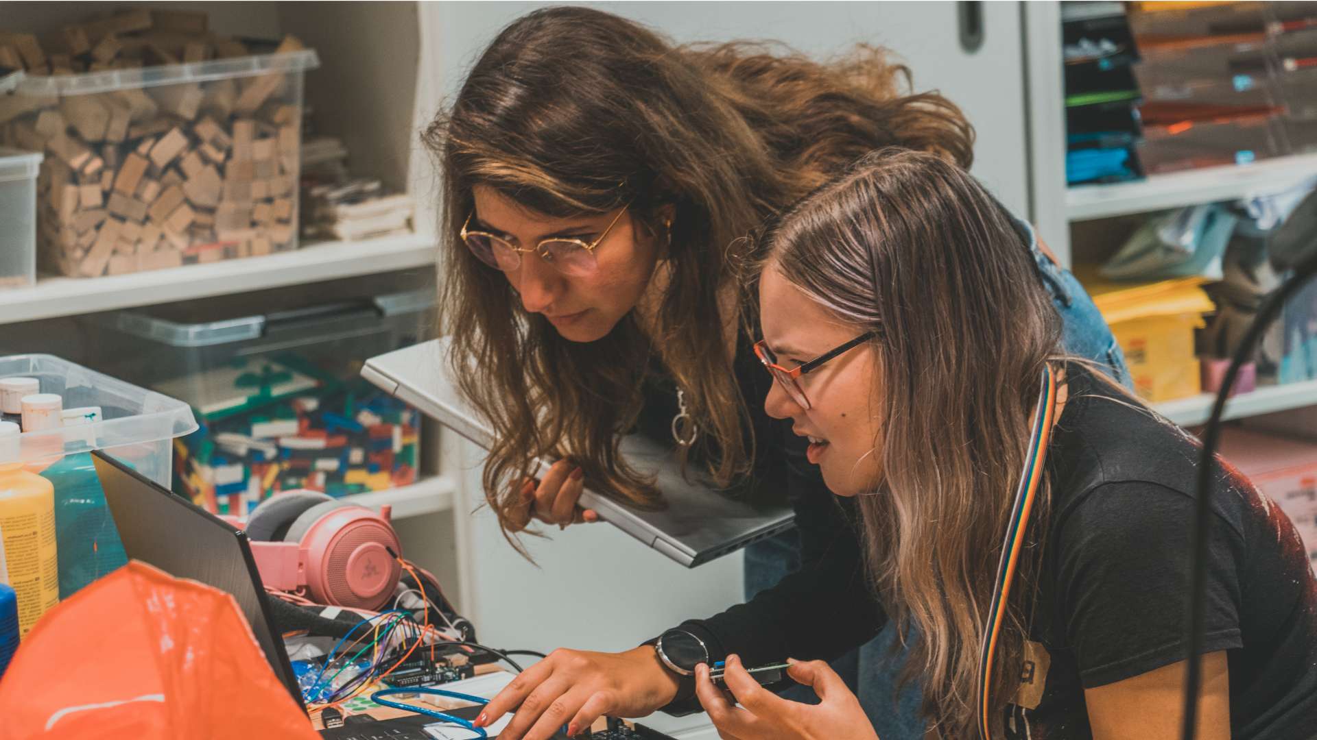 Two women looking intensely at a computer while prototyping a AI program.