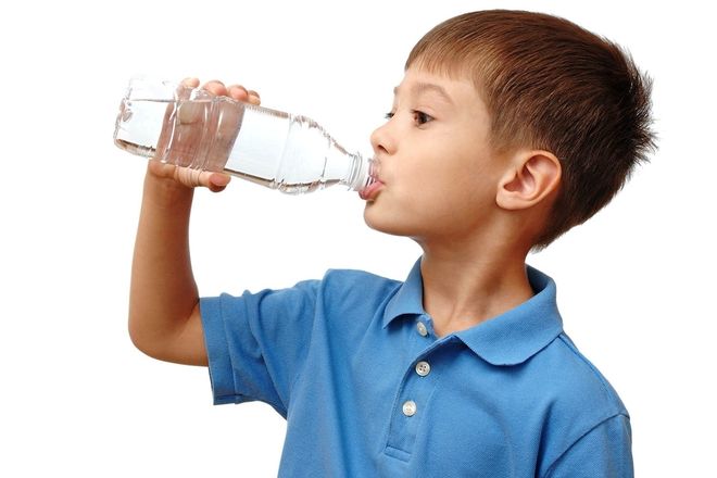 bé trai áo xanh uống nước