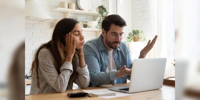 Mortgage down valuations - what to do next? Image of a couple starting at computer screen with frustration.