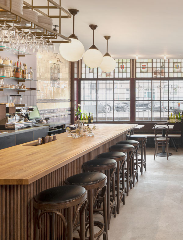 Photo of the bar seats, wood tabletop, bar area, and circular lights