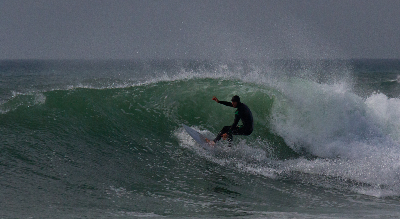 Surfer takes on a wave in Widemouth Bay north Cornwall