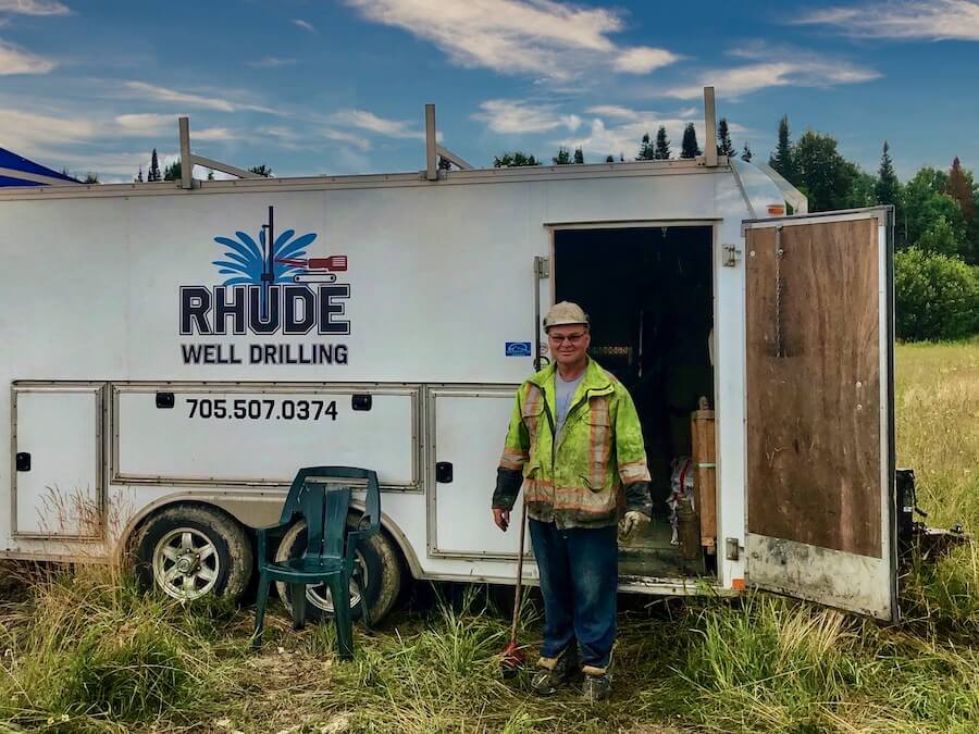 A well decommissioning technician standing in front of a trailer.