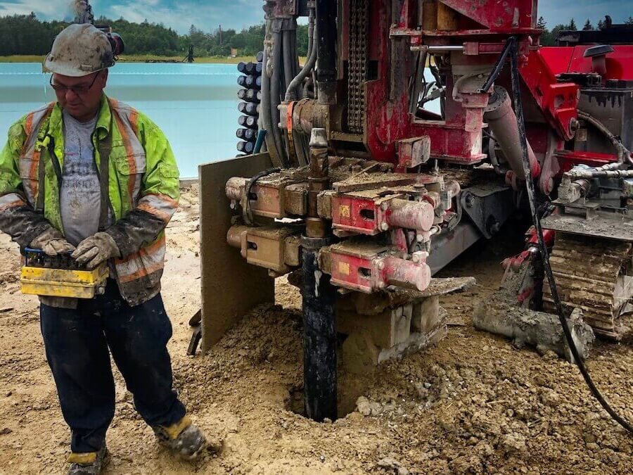 A well technician deepening a well for better water flow using well drilling machine.