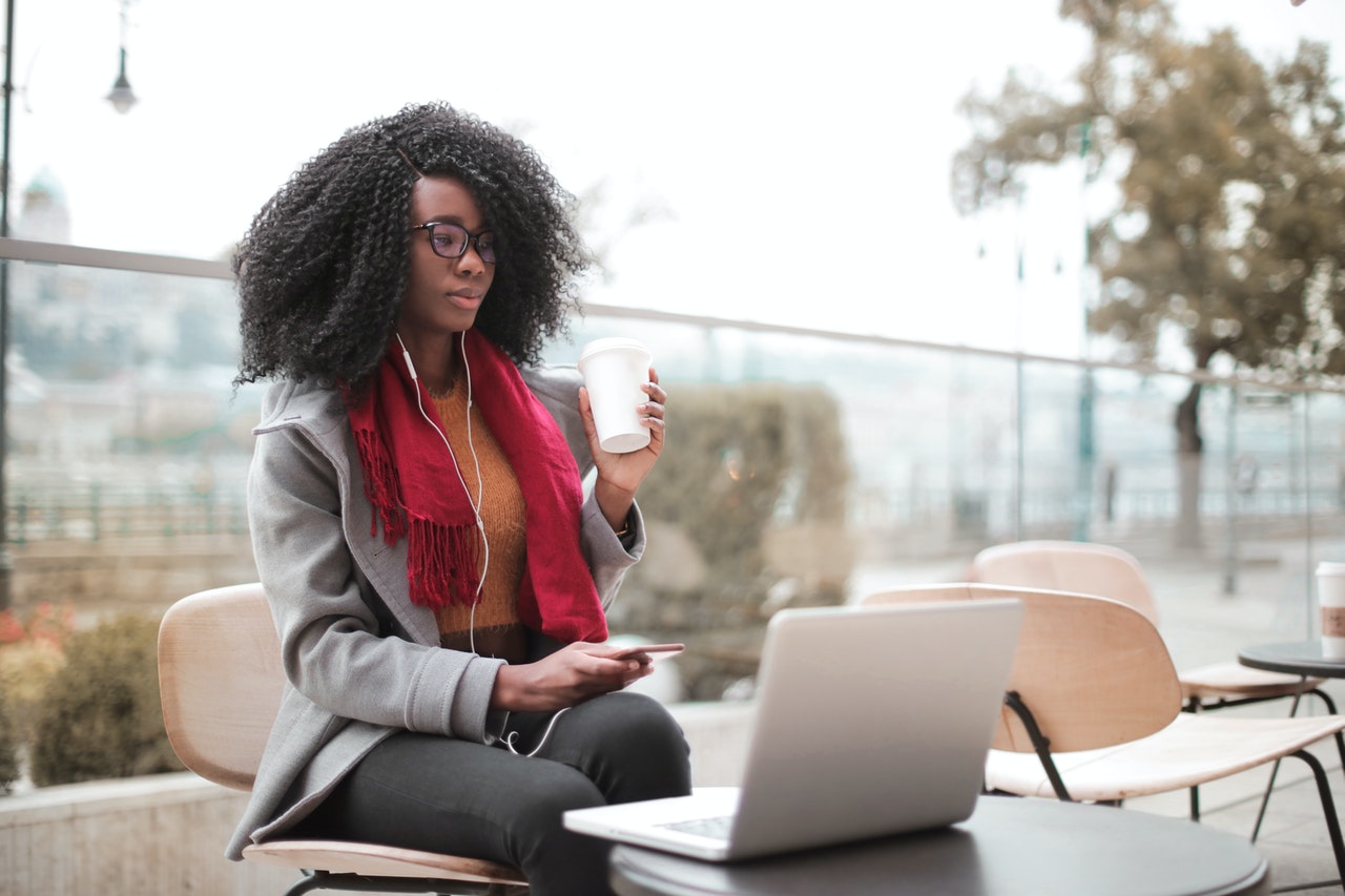 Woman drinking coffee using laptop