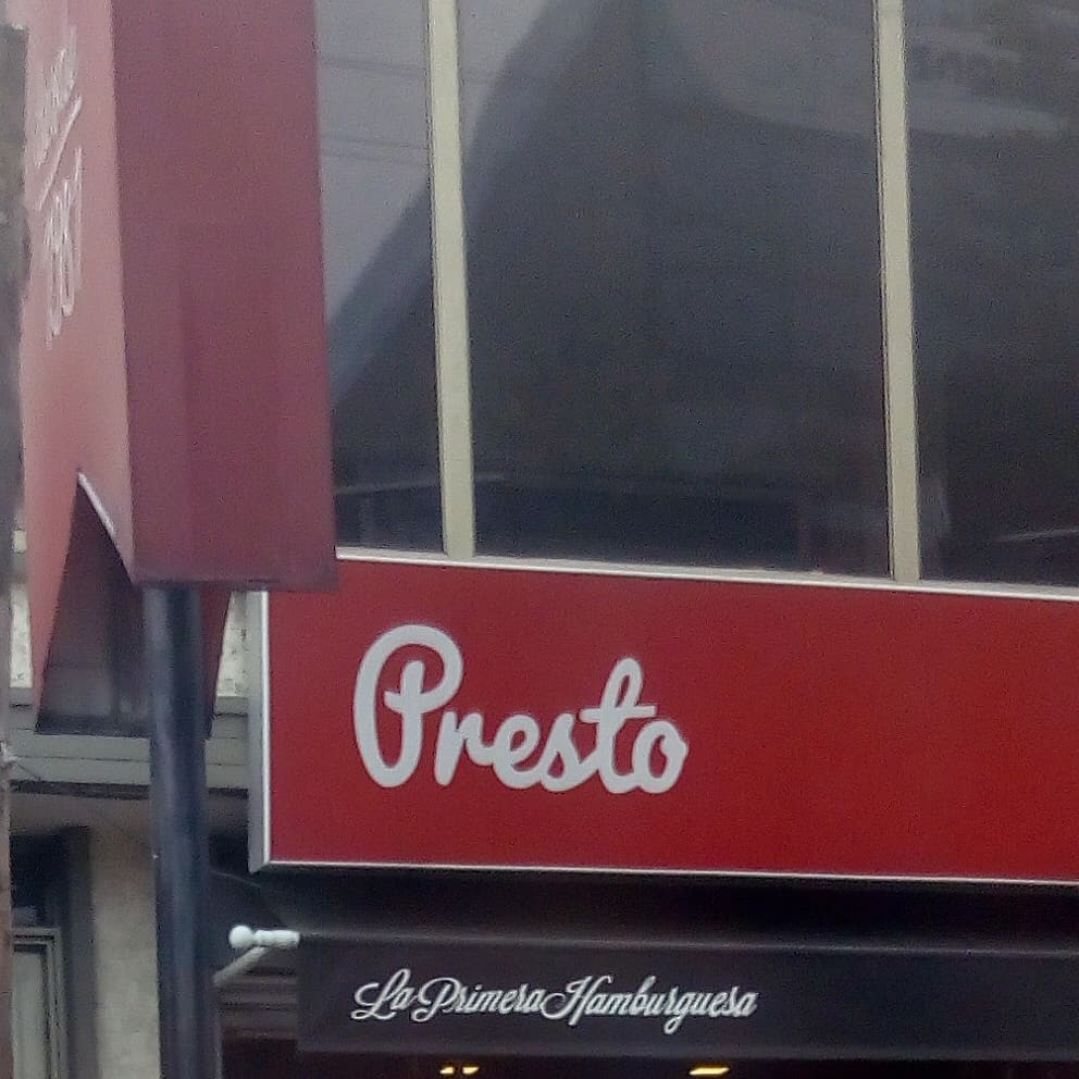 Fachada de local de hamburguesas que dice: Presto, La Primera Hamburguesa.
