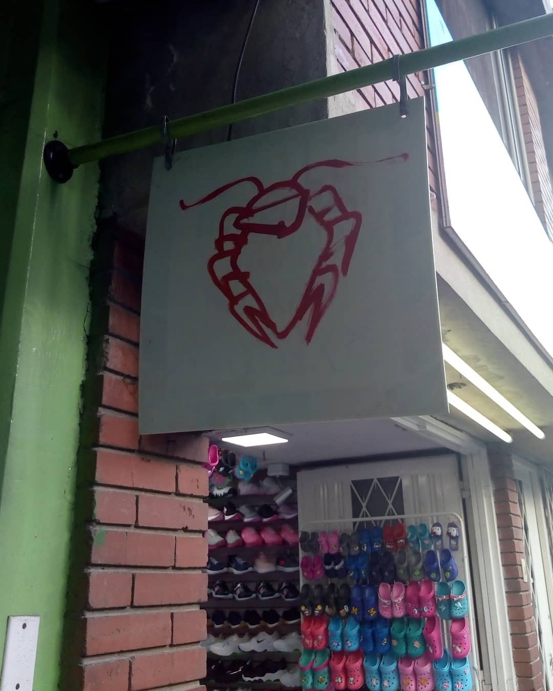 Aviso de local de ropa que tiene un dibujo o grafitti que parece una langosta.