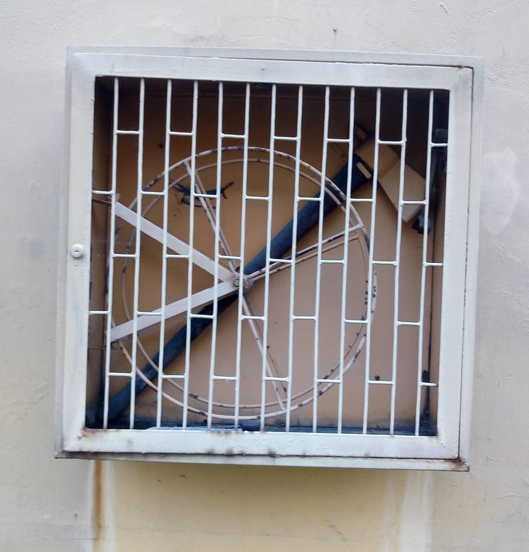 Caja de metal en una pared que tiene una rueda y un hacha en el fondo.