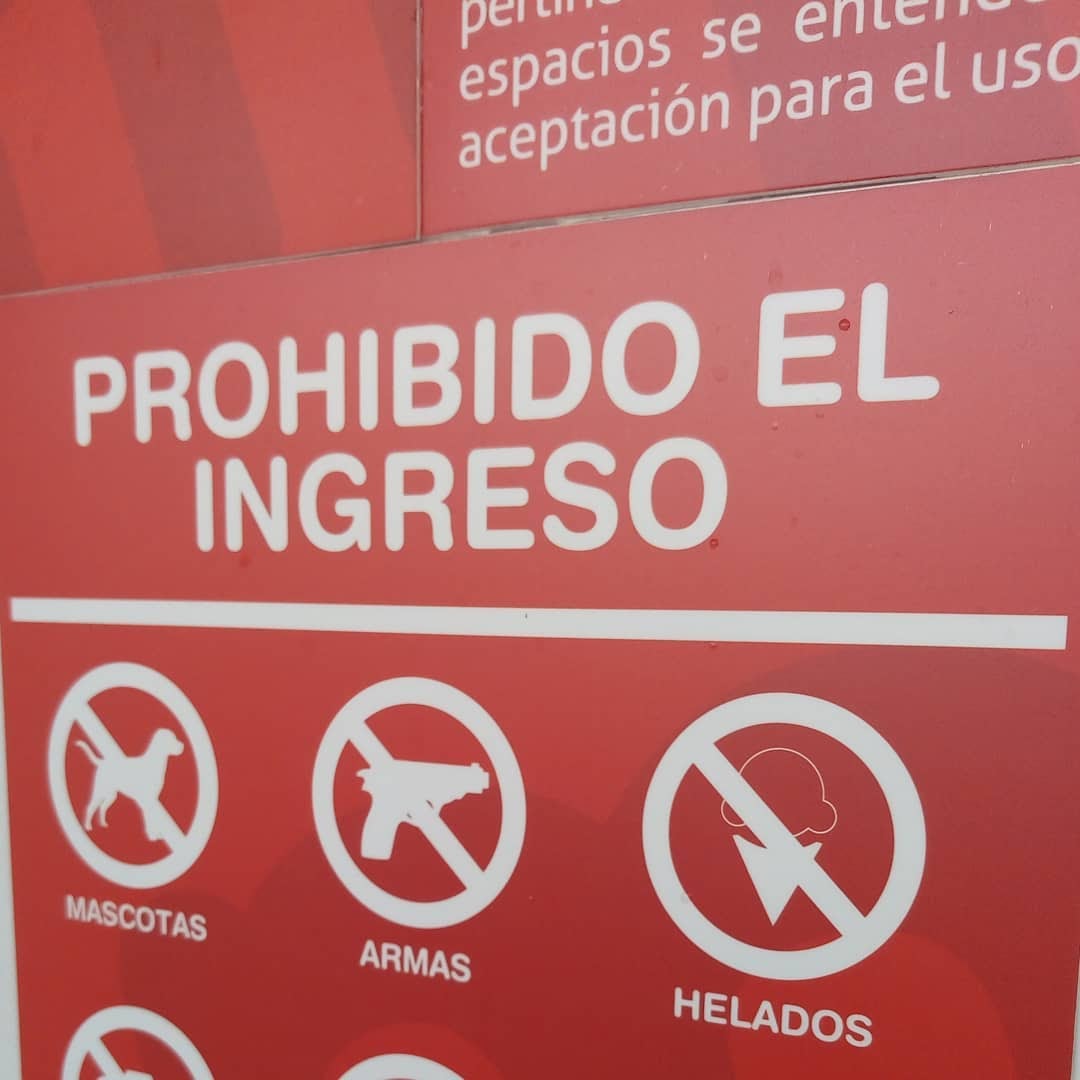Aviso "Prohibido el ingreso", debajo íconos que representan Mascotas, Armas y Helados.