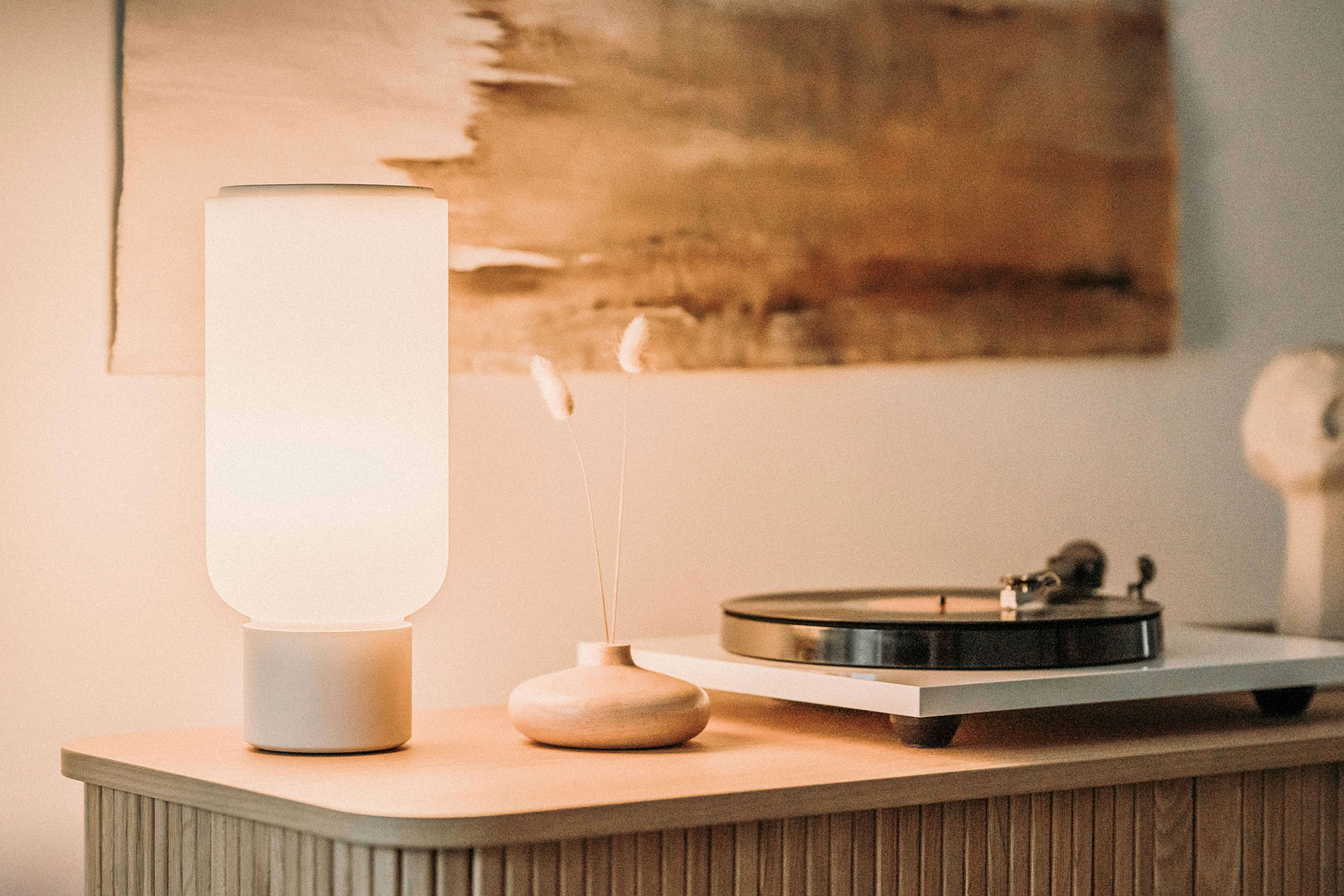 Arpeggio Table Light for Gantri, illuminated and sitting on a minimal sideboard