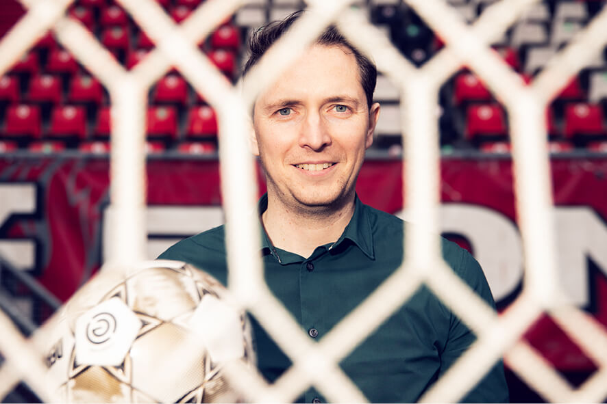 Een voetbal en nette schoenen op het grasveld van FC Twente