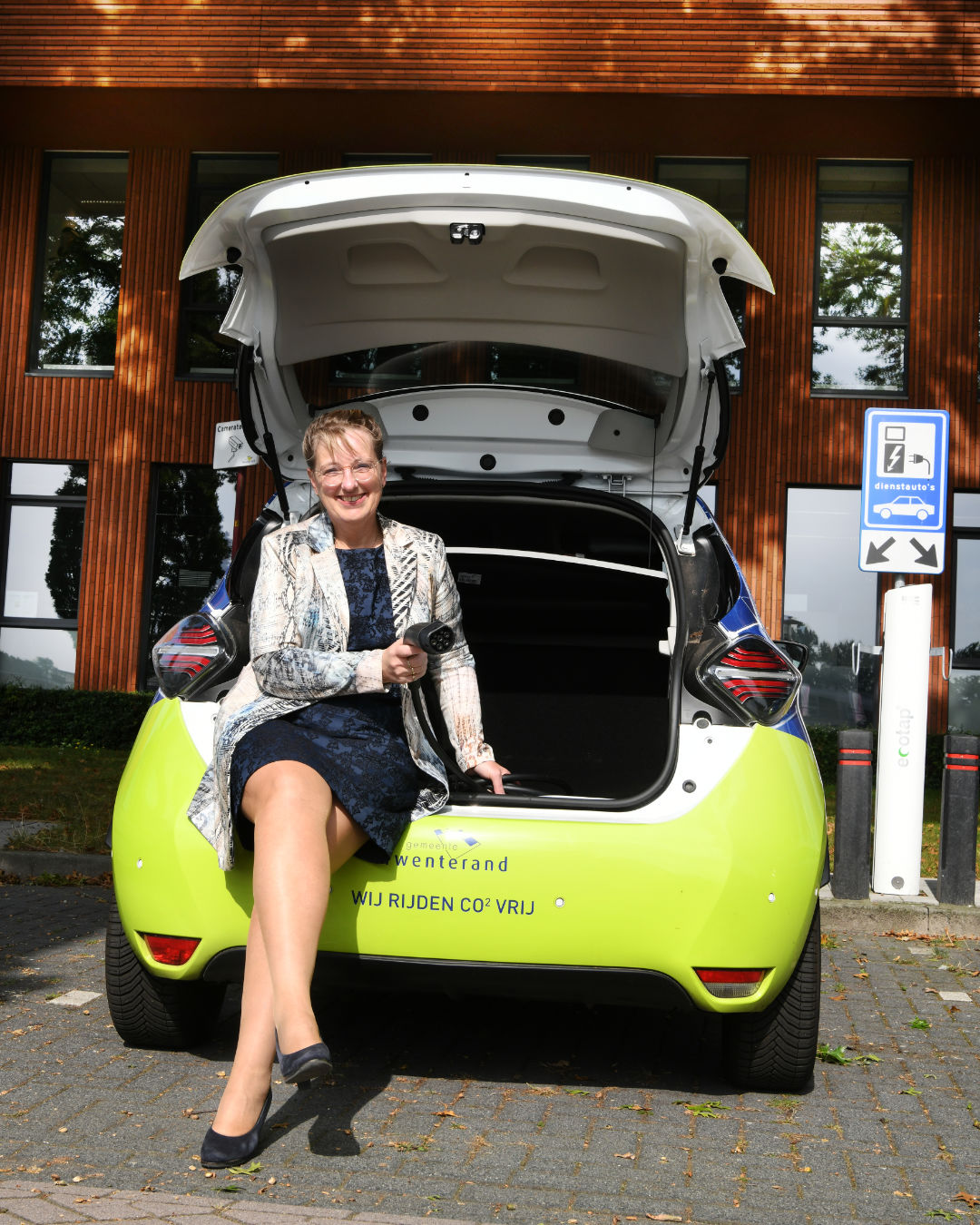 Wethouder Martha van Abbema bij de elektrische auto van Gemeente Twenterand