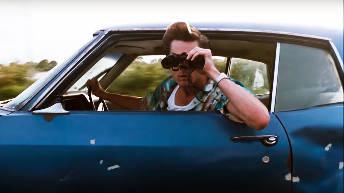 Ace Ventura Movie Picture: The actor looking out of a car with binoculars